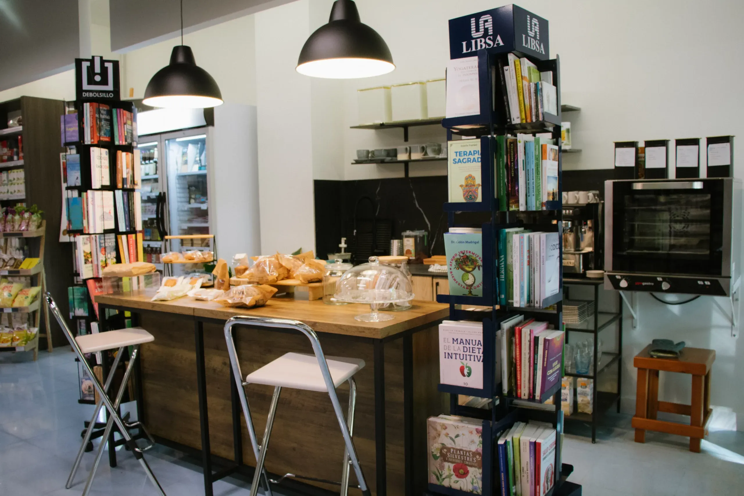 Barra de la eco-cafetería de La Pebrella con bollería y libros